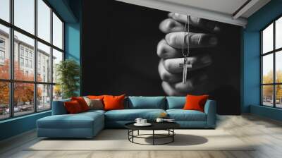 Hands holding cross while praying. Wall mural