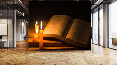 Light candle with holy bible and cross or crucifix on old wooden background in church.Candlelight and open book on vintage wood table christianity study and reading in home.Concept of christ religion Wall mural