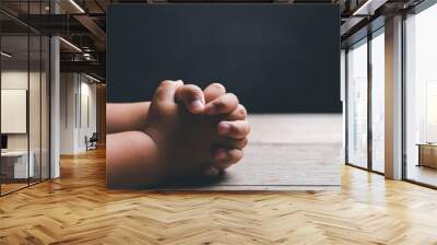 Little boy praying to God with hands held together. Child worship to God. Cute little boy in a Christian family. Wall mural