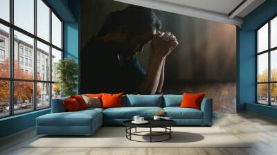 Prayer person hand in black background. Christian catholic woman are praying to god in dark at church. Girl believe and faith in jesus christ. Christ religion and christianity worship or pray concept. Wall mural