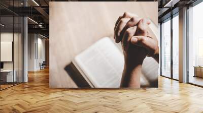 Spirituality and religion, Hands folded in prayer on a Holy Bible in church concept for faith. Wall mural