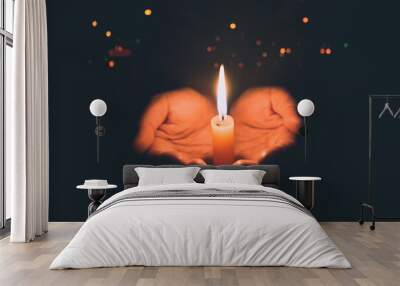 Woman hands praying in the light candles Wall mural