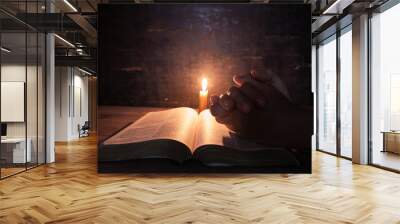 women praying on the Bible in the light candles selective focus. Wall mural