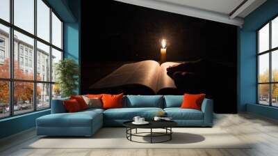 women praying on the Bible in the light candles selective focus. Wall mural