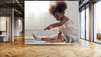 Cute little mixed race toddler girl playing with wooden toy xylophone. Wall mural