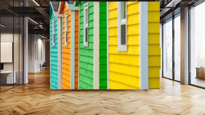 The exterior of a bright orange and green narrow wooden horizontal clapboard wall of a house with one vinyl window. The trim on the glass panes is white in color.  Wall mural