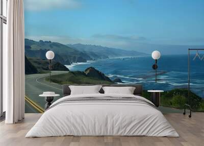 Driving along a stunning coastal road with ocean views, sunny skies, and a clear horizon. Wall mural