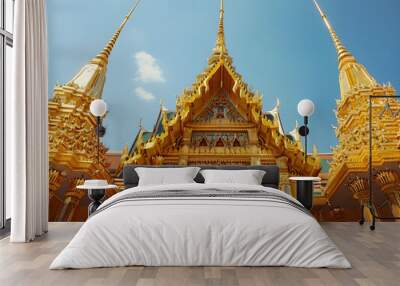 Golden spires and intricate carvings adorn a beautiful Thai temple with a serene atmosphere. Wall mural