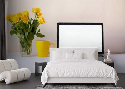 Laptop computer mockup on work desk. Close-up scene with yellow rosess on table. Modern, thin laptop design. White background. Isolated screen for mockup. Female desktop. Home office. Spring design Wall mural