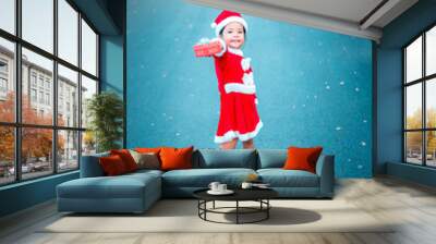 little asian girl in red Santa Claus costume with present box on the road Wall mural