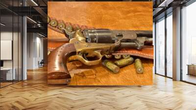 Navy colt firearm with gun belt and bullets on a weathered bar top Wall mural