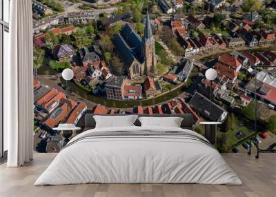 Aerial historic dutch village Maasland with central church and canal curving around Wall mural