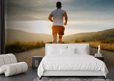 Rear view of a man's feet before running. Adult man doing exercise running and walking on country road in the morning with sunrise background. Concept of health and lifestyle Wall mural