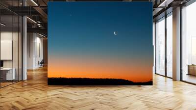 A crescent moon in and the north star in a vast blue sky at twilight with a burnt orange horizon above a silhouette of the land. Concepts of transition, the twilight of life , new day. Copy space. Wall mural