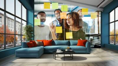 Another idea Lets write it down. Shot of colleagues having a brainstorming session with sticky notes at work. Wall mural