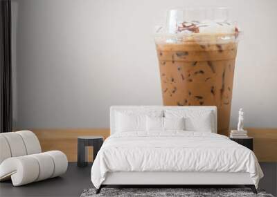 Iced coffee in plastic cup on wooden table at cafe Wall mural