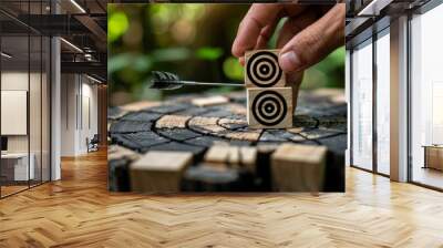 Arrow and target symbols on wooden blocks with a businessman hand placing the target symbol. Goal or agenda setting in business concept Wall mural