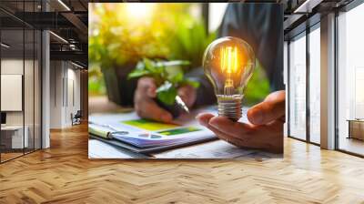 Businessman Holding Lightbulb on Desk with Tax Forms Strategic Planning for Green Growth Wall mural