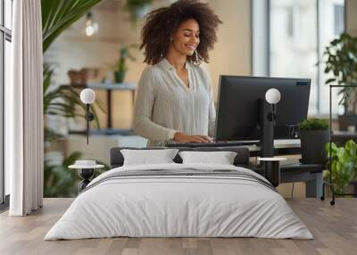 Woman using standing desk in modern office for improved ergonomics and wellness Wall mural