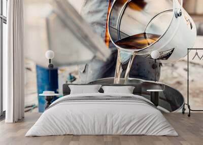 Professional worker mixes two chemical compounds in the metal bucket  Wall mural