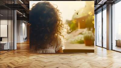 Back view of young girl looking at garden from house Wall mural