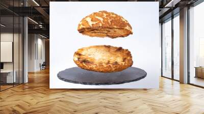 empty burger bun, levitating over a black stone tile, isolated on white background. Selective focus Wall mural