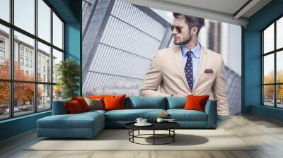 Handsome man in bright suit against the city Wall mural