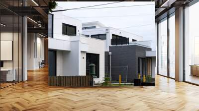 A newly built modern suburban home with a contemporary exterior design. The construction site of two story homes is nearly finished. Concept of real estate, home ownership and housing Wall mural