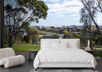 A public park features vast green open spaces, with sleek new suburban houses in the distance. Geelong VIC Australia. Concept of real estate development, housing market, property investment. Wall mural