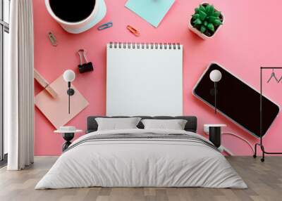 business flat lay on pink background with open note pad ,smart phone, paper note and coffee cup   Wall mural