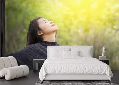 happy Asian woman arms up and breathing deep outdoors and relaxing with fresh air in nature  Wall mural