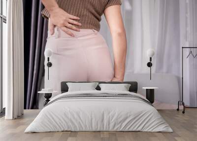 Sciatica concept with woman feeling nerve pain from lower back and goes down to legs Wall mural