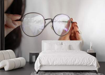 woman hand hand holding eyeglasses closeup ,eye care concept  Wall mural