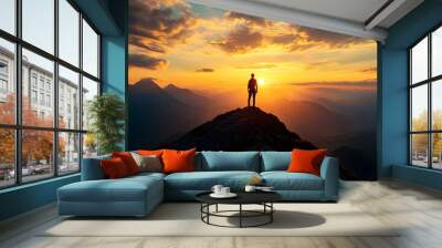 A solitary hiker stands on the summit of a majestic mountain their silhouette outlined against a breathtaking sunset sky  This epic Wall mural