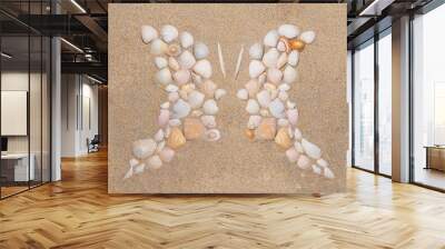 Butterfly or two profile side silhouette created of sea shells on sand background. Top view optical illusion appropriate to illustrate human friendship, relationship, emotions and communication. Wall mural