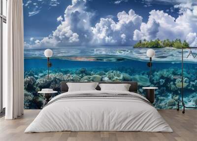 Above and below surface of the Caribbean sea with coral reef underwater and a cloudy blue sky. Wall mural