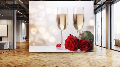 Two glasses of champagne with a red rose on a snowy floor. Bokeh lights in the background. Wall mural