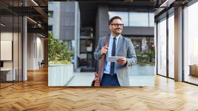 Confident Businessman Walking Outside Office Building With Tablet Wall mural