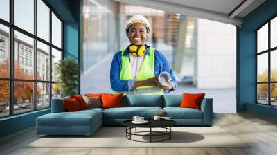 female construction engineer. architect with a blueprints at a construction site. young woman look i Wall mural