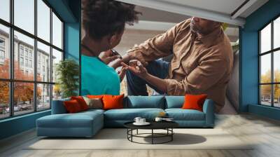 Female healthcare worker holding hands of senior man at care home, focus on hands. Doctor helping old patient with Alzheimer's disease. Female carer holding hands of senior man Wall mural