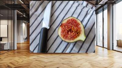 Fresh ripe figs on table background. Healthy Mediterranean fig fruit. Beautiful blue-violet figs with empty copy space close up. Whole figs and one fig sliced in half on top of a teak garden table. Fo Wall mural