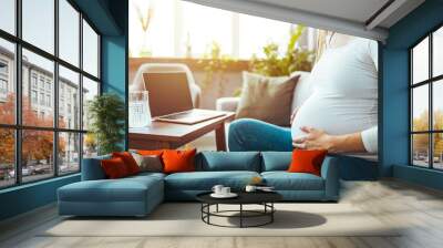 Future attractive cheerful mum sitting in chair in bright light flat and using pc laptop while speaking with intelligent doctor about pregnancy.  Wall mural