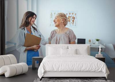 Internist and patient during medical consultation in the doctor's office. Doctor working in the office and listening to the patient, she is explaining her symptoms, healtcare and assistance concept Wall mural