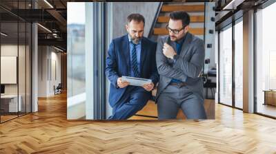 Logo, collaboration and businessman talking to an employee about a development project. Shot of two businessmen walking and talking together in the lobby of an office building Wall mural