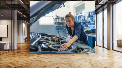 mechanic working under the hood at the repair garage. portrait of a happy mechanic woman working on  Wall mural