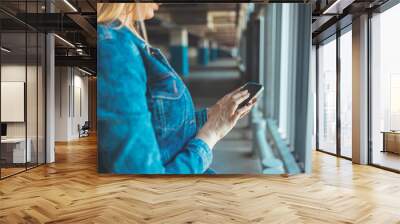 Photo of Businesswoman sending a message with a smartphone. A young proud businesswoman is talking on her mobile phone with a client and reading order. A young Caucasian woman standing nearby car  Wall mural