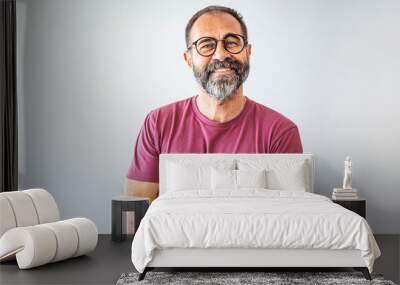 Portrait of mature businessman. Male executive is wearing T-shirt. Professional is smiling against gray background. Confident businessman with arms crossed. Mature mixed race man smiling Wall mural