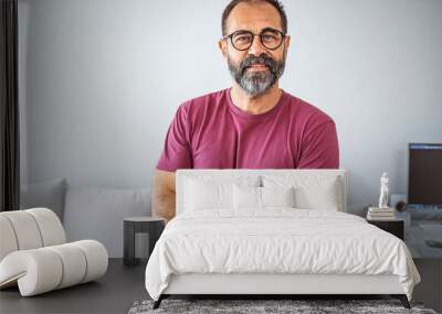 Smiling mature man wearing spectacles looking at camera. Portrait of confident man at home. Successful entrepreneur feeling satisfied. Portrait of confident mature businessman. Wall mural