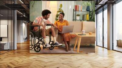 Black young man with disability visiting his friend at home to discuss university project Wall mural