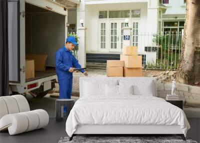 Delivery service worker loading his truck with cardboard boxes Wall mural